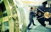 Do bank stocks go up when interest rates rise? Image of a bank manager rolling back the safe in a bank